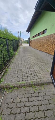 a brick road next to a building with a fence at Chmurka in Górno