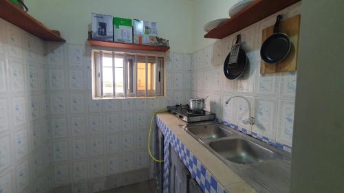 a small kitchen with a sink and a window at Appartement meublé à Fidjrossè Cotonou in Cotonou