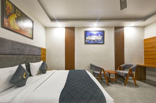 a hotel room with a bed and a table and chairs at Kelvish Hotel- Delhi Airport in New Delhi