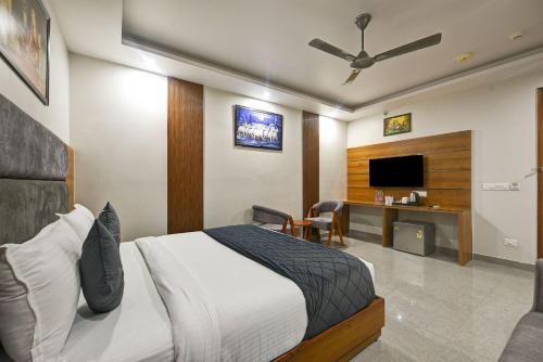 a hotel room with a bed and a tv at Kelvish Hotel- Delhi Airport in New Delhi