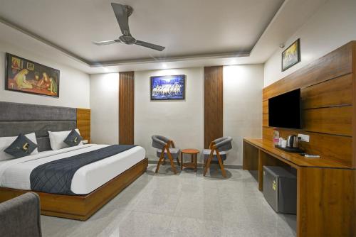 a hotel room with a bed and a tv at Kelvish Hotel- Delhi Airport in New Delhi