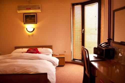 a bedroom with a bed and a desk with a computer at Taxi Bar Motel in Bosanska Gradiška