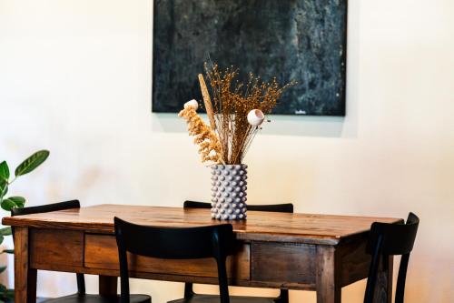 a dining room table with a vase of flowers on it at Podere Dell'Arco Country Charme in Viterbo