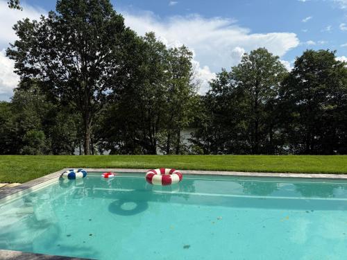 a swimming pool with balls on top of it at Kalbornia LAKE & POOL HOUSE by JWPM in Brzeźno Mazurskie