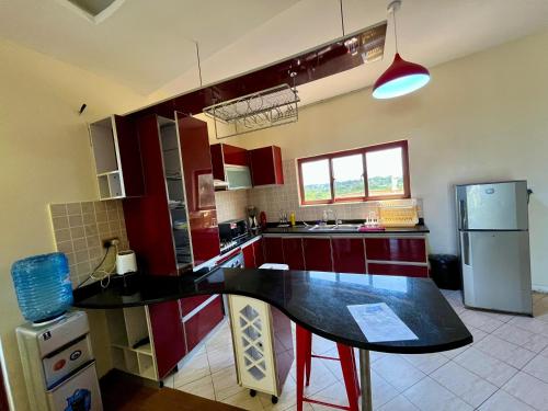 a kitchen with red cabinets and a black counter top at Seabreeze apartments in Mombasa