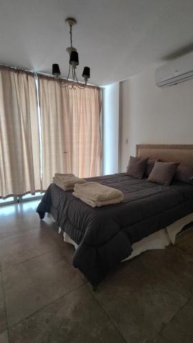 a bedroom with a large bed in front of a window at El Hornero Barraca Puerto in Concepción del Uruguay