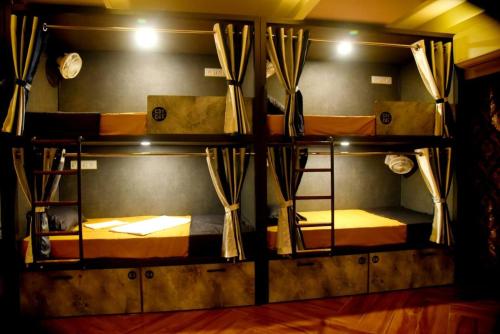 a room with three bunk beds with a mirror at Backpackers's Village in Jāmb