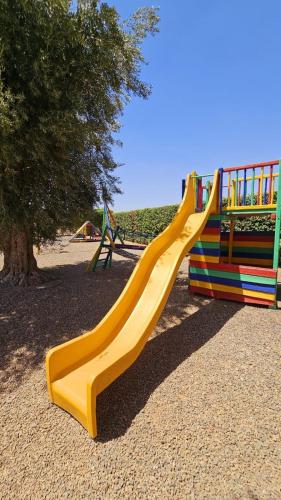 a yellow slide in a park with a playground at oasis de paix in Aït Amara