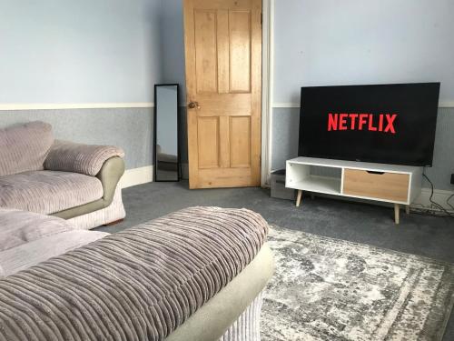 a living room with a tv and a couch at Castle Donington 5 Bed House 2 Baths Near EMA And Donington Park in Castle Donington