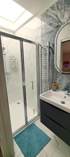 a bathroom with a shower and a tub and a sink at Lily Lake Lodge in Chelmsford