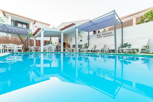 a swimming pool with blue water in front of a building at 4Ever Palace Design&Nature in Alcácer do Sal