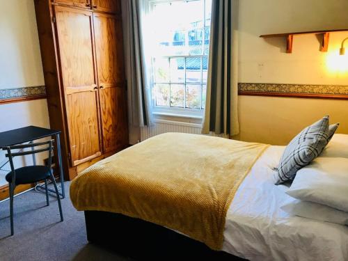 キャッスル・ドニントンにあるCastle Donington 5 Bed House 2 Baths Near EMA And Donington Parkのベッドと机と窓のある寝室