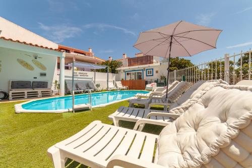 a group of white chairs and an umbrella next to a pool at 4Ever Palace Design&Nature in Alcácer do Sal