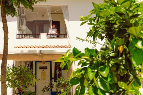 a woman sitting on a balcony of a building at 4Ever Palace Design&Nature in Alcácer do Sal