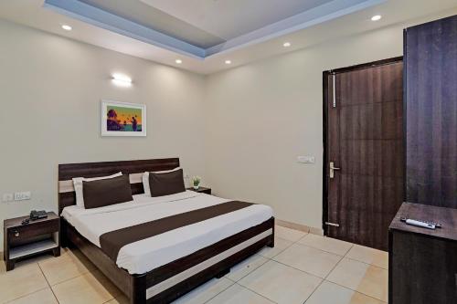 a bedroom with a large bed and a television at Townhouse Akshay Hotel in Gurgaon