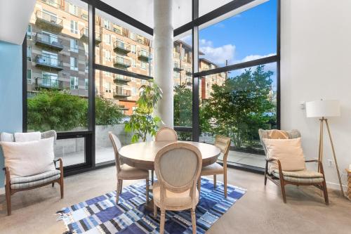 a dining room with a table and chairs and large windows at Airy and Open Corner Loft - 92 Walkscore in Redmond