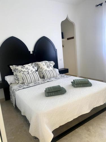 une chambre avec un grand lit avec deux oreillers dessus dans l'établissement villa 8 personnes clim, piscine, parking, à Piolenc