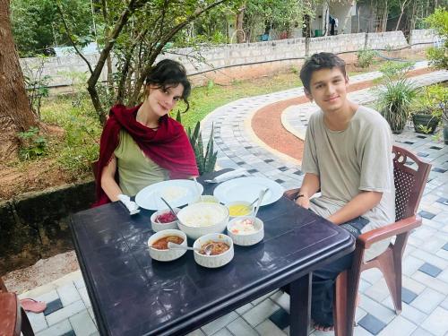 a man and a woman sitting at a table with food at Mashi's Villa in Sigiriya