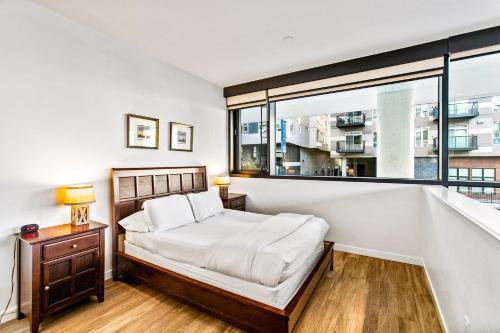 a bedroom with a bed and a large window at Airy and Open Corner Loft - 92 Walkscore in Redmond