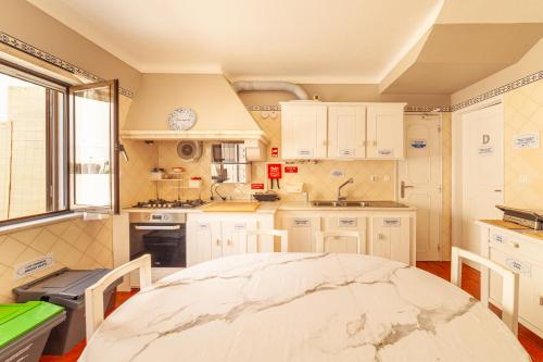 a kitchen with white cabinets and a table in it at 4Ever Palace Design&Nature in Alcácer do Sal