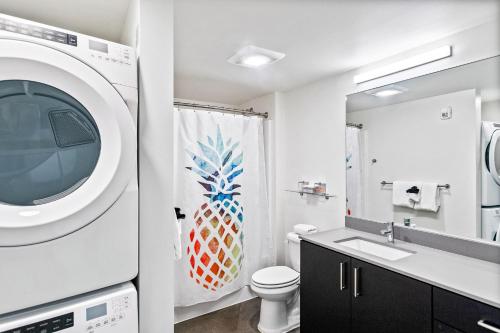 a bathroom with a toilet and a washing machine at Airy and Open Corner Loft - 92 Walkscore in Redmond