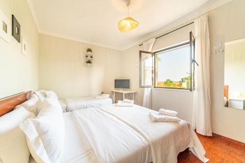 a white bedroom with two beds and a window at 4Ever Palace Design&Nature in Alcácer do Sal