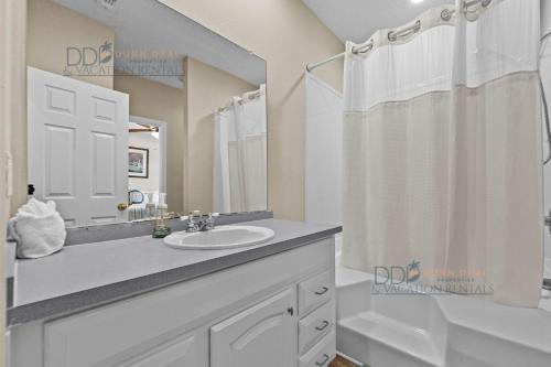 a white bathroom with a sink and a mirror at Legacy Villa 1504 in Gulfport
