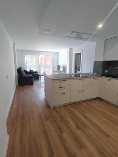 eine leere Küche und ein Wohnzimmer mit Holzböden in der Unterkunft Esencia Mediterránea in Vinarós