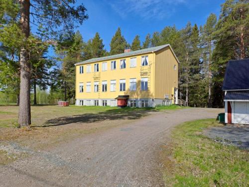 a large yellow building next to a dirt road at Skolan - Boende Vindelälven in Gargnäs