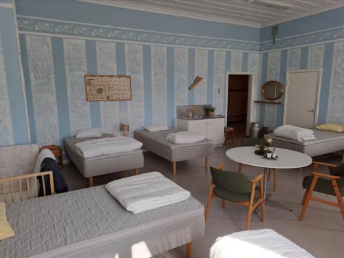 a room with several beds and a table and chairs at Skolan - Boende Vindelälven in Gargnäs