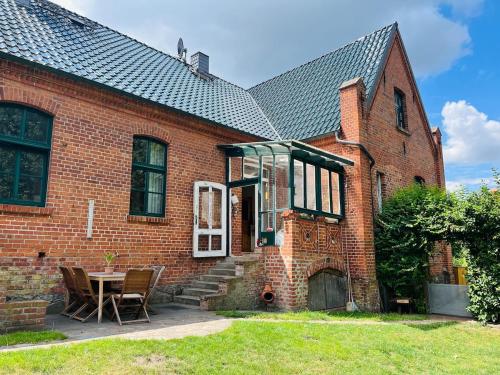a brick house with a table and chairs in the yard at Landhaus Kloster Marienfließ in Stepenitz