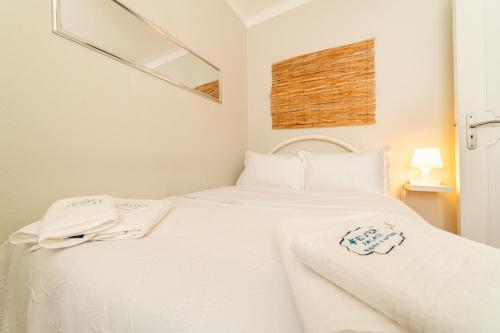 a white bed with white sheets and towels on it at 4Ever Palace Design&Nature in Alcácer do Sal