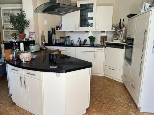 a kitchen with white cabinets and a black counter top at Landhaus Kloster Marienfließ in Stepenitz