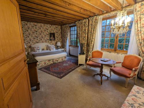 a bedroom with a bed and a table and chairs at Les Hauts de Loire Relais & Châteaux in Onzain