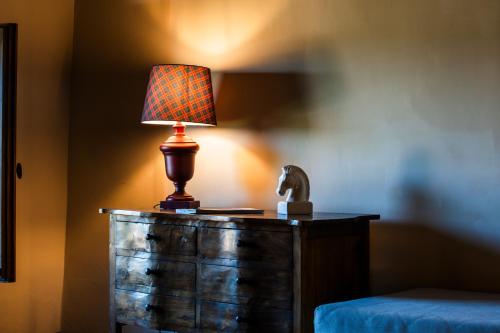 a lamp on top of a dresser next to a bed at Podere Dell'Arco Country Charme in Viterbo