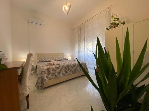 奥尔比亚Passa Parola的一间带床和盆栽的卧室