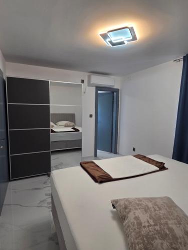 a white bedroom with two beds and a window at Mateo in Novi Vinodolski