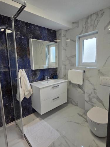 a bathroom with a sink and a toilet and a shower at Mateo in Novi Vinodolski