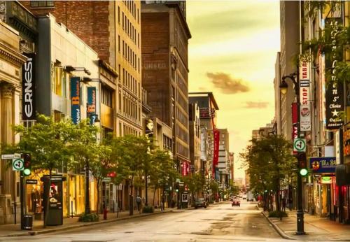 a city street with buildings and street lights and trees at LiV MTL Main in Montréal