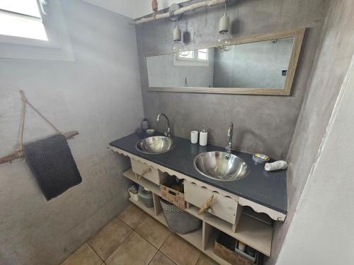 a bathroom with two sinks and a mirror at CHARMANT HAUT DE VILLA AVEC PISCINE PARTAGEE in Le Vauclin