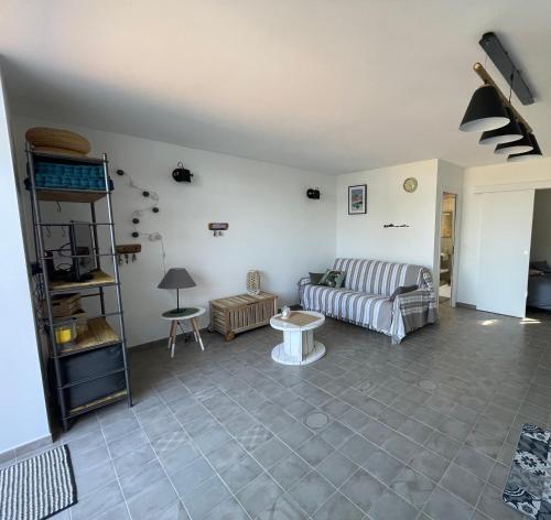 a living room with a couch and a table at logement de charme en bord de plage in Lumio