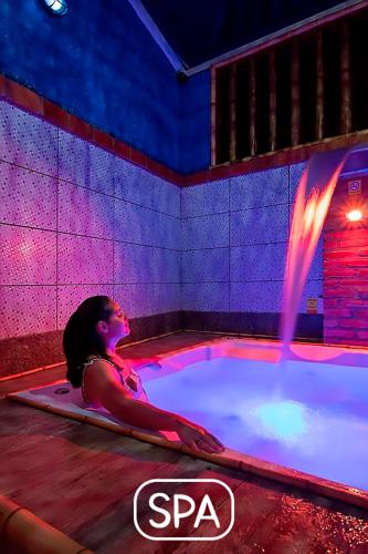 a woman is sitting in a hot tub at Hotel Natural - SPA & Lazer in Brotas