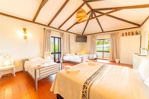 a bedroom with two beds in a room with windows at 4Ever Palace Design&Nature in Alcácer do Sal