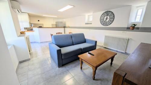 a living room with a blue couch and a table at Rez de jardin chez Elise in Saint-Christol-lès-Alès