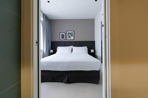 a bedroom with a large white bed and a mirror at Hotel Stelvio Tirano in Tirano