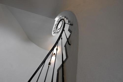 a clock on the side of a stair case at Hotel Stelvio Tirano in Tirano