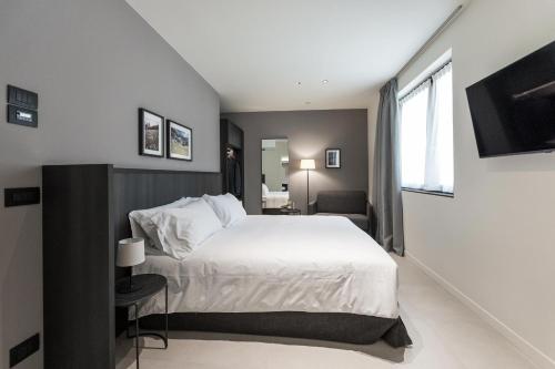 a bedroom with a large white bed and a window at Hotel Stelvio Tirano in Tirano