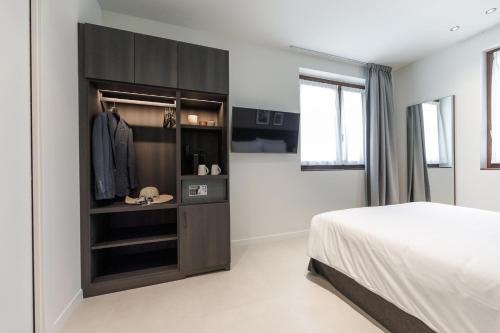 a bedroom with a bed and a dresser with a closet at Hotel Stelvio Tirano in Tirano