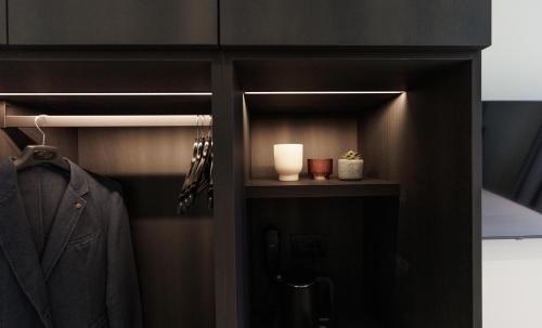 a black closet with a coat and a lamp at Hotel Stelvio Tirano in Tirano
