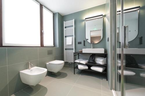 a bathroom with a sink toilet and a mirror at Hotel Stelvio Tirano in Tirano